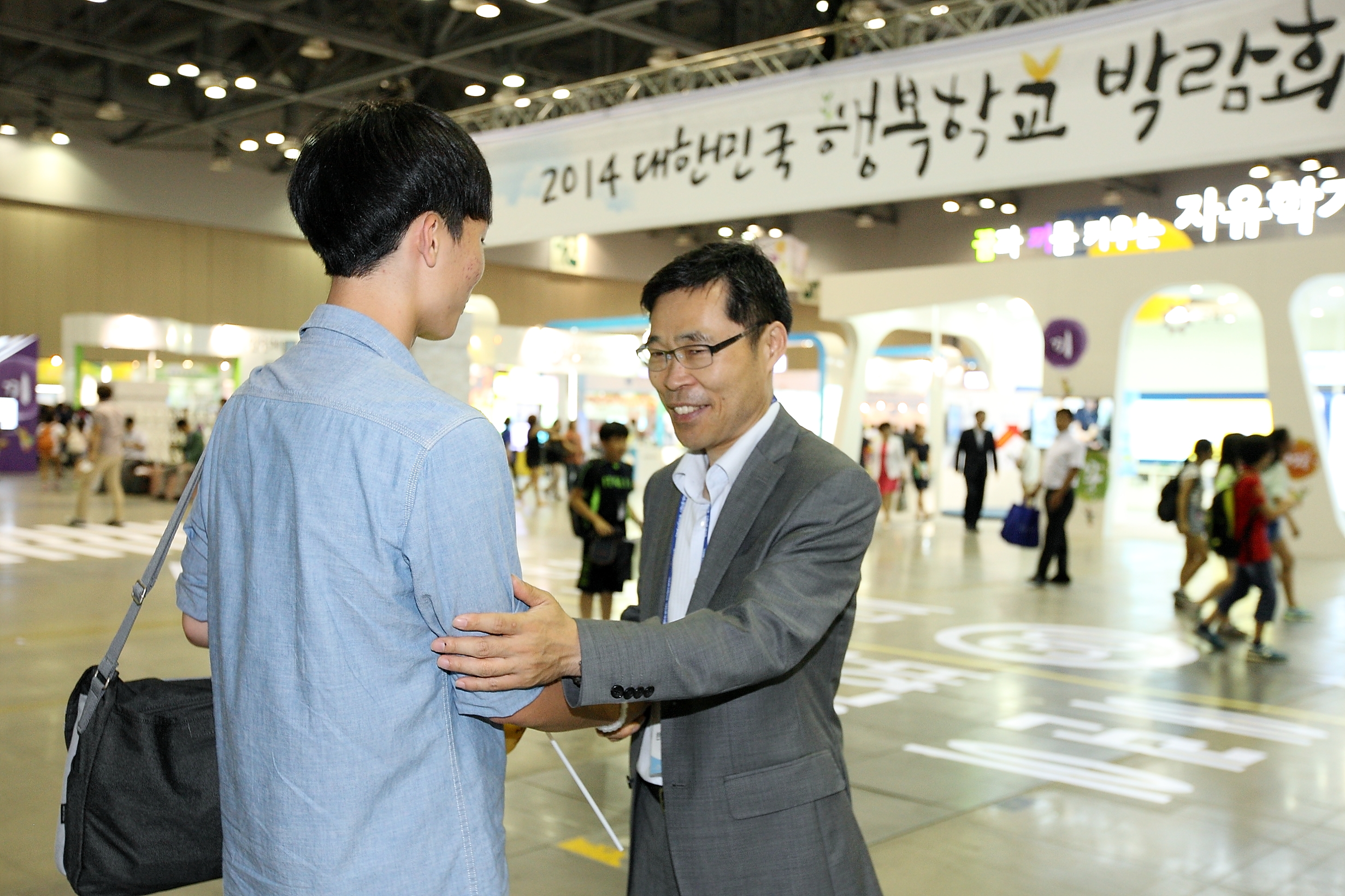 2014 대한민국 행복학교 박람회 참여 학생을 격려해 주는 모습
